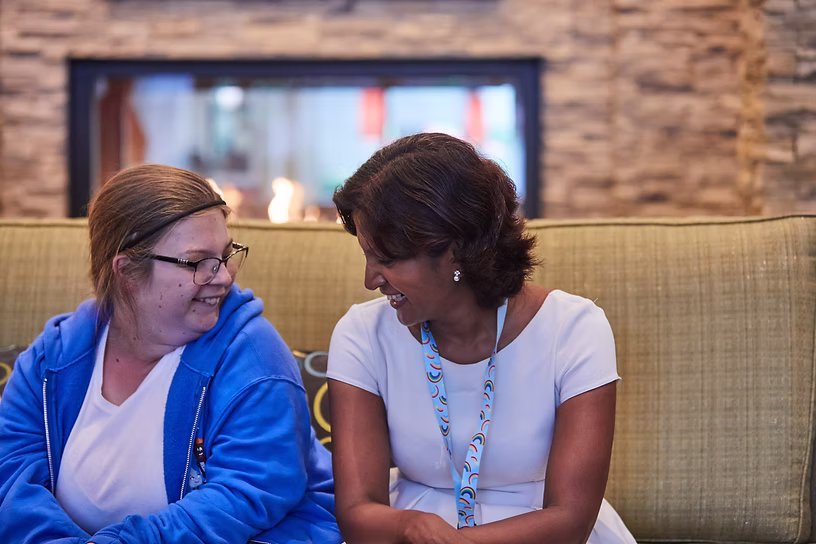 Mary, who has HNRNPU-NDD, chatting with Dr. Meena Balasubramanian, a clinical lecturer and geneticist from University of Sheffield, one HNRNP Family Foundation research collaborator